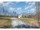 Wide shot of a two-story home with beautiful sky and a long gravel driveway at 9260 Ahavah Ln, Indian Trail, NC 28079