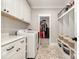 Laundry room featuring front load washer and dryer with white cabinets and brick floor at 9260 Ahavah Ln, Indian Trail, NC 28079