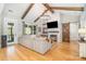 A spacious living room featuring a cozy gray sectional sofa, fireplace, hardwood floors, and exposed wooden beams at 9260 Ahavah Ln, Indian Trail, NC 28079