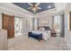 The primary suite features a tray ceiling, plush carpet, a barn door to the ensuite, and plenty of natural light at 9260 Ahavah Ln, Indian Trail, NC 28079