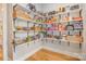 Spacious walk-in pantry featuring abundant white shelving with black brackets stocked with an assortment of goods at 9260 Ahavah Ln, Indian Trail, NC 28079