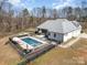 Aerial view of a large private pool with a hot tub and surrounding fence and seating area at 9260 Ahavah Ln, Indian Trail, NC 28079