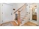 View of a staircase with wooden handrail and a black baby safety gate at 9260 Ahavah Ln, Indian Trail, NC 28079
