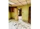 A view of the open living area with damaged walls, flooring, and access to other spaces at 981 15Th St # 16, Lancaster, SC 29720