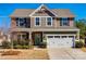 Charming two-story home with stone and shingle siding, attached two-car garage, and well-manicured front lawn at 10379 Black Locust Ln, Charlotte, NC 28215