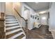 Elegant foyer with wood stairs, coat rack, and dark wood-look floors at 10379 Black Locust Ln, Charlotte, NC 28215