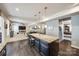 Open-concept kitchen island featuring granite countertops, dark cabinetry, and pendant lighting, perfect for entertaining at 10379 Black Locust Ln, Charlotte, NC 28215