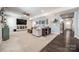 Spacious living room featuring a large TV, cozy seating, and a view to the entryway, perfect for relaxation at 10379 Black Locust Ln, Charlotte, NC 28215
