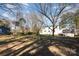 Spacious backyard featuring a grassy lawn, mature trees, and neighboring homes at 1201 Edgefield Ave, Gastonia, NC 28052