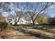 Lush backyard with well-kept lawn, mature trees, and a path leading to the white house at 1201 Edgefield Ave, Gastonia, NC 28052