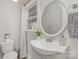 Well-lit bathroom featuring a stylish vanity, oval mirror, and neutral decor at 1201 Edgefield Ave, Gastonia, NC 28052