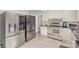 Kitchen showcasing stainless steel appliances, grey tile flooring, and adjacent refrigerator at 1201 Edgefield Ave, Gastonia, NC 28052