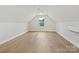 Spacious attic bedroom with hardwood floors, large window, and a ceiling fan at 1467 Centennial Dr, Rock Hill, SC 29732