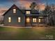 Charming home featuring a covered porch, brick accents, and a well-maintained yard at dusk at 1467 Centennial Dr, Rock Hill, SC 29732