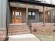 Covered front porch with wood columns, brick accents, and a wooden front door at 1467 Centennial Dr, Rock Hill, SC 29732