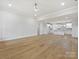 Minimalist living room with hardwood floors, white trim, and view of open kitchen at 1467 Centennial Dr, Rock Hill, SC 29732