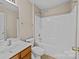 Neutral bathroom featuring a tub with shower, single sink vanity, toilet, and light beige colored walls at 15662 King Louis Ct, Charlotte, NC 28277