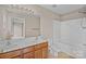 Bathroom with dual sinks, wood cabinetry, and a shower-tub combination at 15662 King Louis Ct, Charlotte, NC 28277
