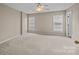 Clean, neutral bedroom with carpet, a ceiling fan, and natural light from two windows at 15662 King Louis Ct, Charlotte, NC 28277