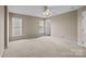 Spacious bedroom featuring neutral walls, carpet, ceiling fan, and multiple windows at 15662 King Louis Ct, Charlotte, NC 28277