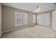 Bedroom featuring a ceiling fan, carpet, closet and large windows to let in plenty of light at 15662 King Louis Ct, Charlotte, NC 28277