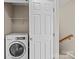Small laundry area with white washer and wire shelf for supplies at 15662 King Louis Ct, Charlotte, NC 28277