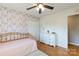 The bedroom features a closet, dresser with drawers, a ceiling fan and unique floral-themed accent wall at 1597 Mcgill St, Rock Hill, SC 29732