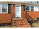 Close up of the front door showcasing the brick stairs, iron railings, and welcome decoration at 1597 Mcgill St, Rock Hill, SC 29732