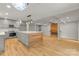 Open-concept kitchen with a large island, gray cabinets, stainless steel appliances, and an open fireplace at 16137 Tana Tea Cir, Tega Cay, SC 29708