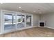 Basement living area with a fireplace and sliding doors opening to an outdoor living space and lake views at 170 W Maranta Rd, Mooresville, NC 28117