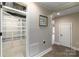 Basement hallway featuring storage room to the left, painting on the wall, and tile flooring at 170 W Maranta Rd, Mooresville, NC 28117