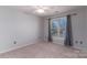 Bright bedroom featuring a window with curtains, carpeting, neutral walls, and ample natural light at 170 W Maranta Rd, Mooresville, NC 28117
