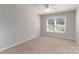Cozy bedroom with neutral walls, plush carpeting, and a large window providing natural light at 170 W Maranta Rd, Mooresville, NC 28117