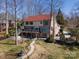 Expansive home featuring a red roof, brick detailing, and lush landscaping in a serene setting at 170 W Maranta Rd, Mooresville, NC 28117