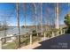 A lake view from the deck framed by bare trees showcases the waterfront beauty of this lakeside home at 170 W Maranta Rd, Mooresville, NC 28117