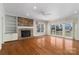 Bright living room with hardwood floors, brick fireplace, and expansive windows overlooking the lake at 170 W Maranta Rd, Mooresville, NC 28117