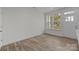 Bright bedroom with wood-look flooring, a window, and a door, ready for personalization at 2013 Near Point Rd # 20, Charlotte, NC 28208
