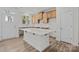 Bright kitchen featuring a quartz island, wooden cabinets, stainless sink, and access to the backyard at 2013 Near Point Rd # 20, Charlotte, NC 28208