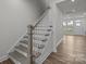 A staircase with hardwood floors, and a light-gray handrail at 2013 Near Point Rd # 20, Charlotte, NC 28208