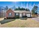 Charming brick home featuring green shutters, a well-manicured lawn, and attached garage at 2107 Summerfield Cir, Conover, NC 28613