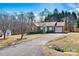 Well-maintained property featuring a brick facade, mature trees, and paved driveway at 2107 Summerfield Cir, Conover, NC 28613