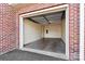 Spacious single car garage showcasing interior brick detail, mechanical door and concrete flooring at 2107 Summerfield Cir, Conover, NC 28613