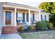 Inviting front porch with wicker furniture, decorative pillows, and landscaped flower bed at 217 Pine Meadows Cir, Hickory, NC 28601