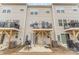 Backyard view of townhouse complex with patios, grills, and outdoor living spaces at 2311 Doby Creek Ln, Charlotte, NC 28262