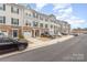 Row of townhomes featuring stone accents, garages, and plenty of parking at 2311 Doby Creek Ln, Charlotte, NC 28262