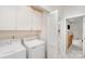 Organized laundry room with washer, dryer, white cabinets and storage at 2311 Doby Creek Ln, Charlotte, NC 28262
