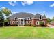 Stunning brick home featuring a manicured lawn, arched windows, and a grand entrance portico at 249 Blue Heron Dr, Rock Hill, SC 29732
