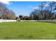 Large, fenced backyard featuring a well-maintained lawn, shed, and mature trees, providing ample space at 2701 Sharon Rd, Charlotte, NC 28211