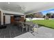 A covered patio features slate flooring, a dining table with seating, and brick wall with mounted television at 2701 Sharon Rd, Charlotte, NC 28211