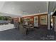 A covered patio boasts slate flooring, a dining table, wicker chairs, and views of the backyard at 2701 Sharon Rd, Charlotte, NC 28211